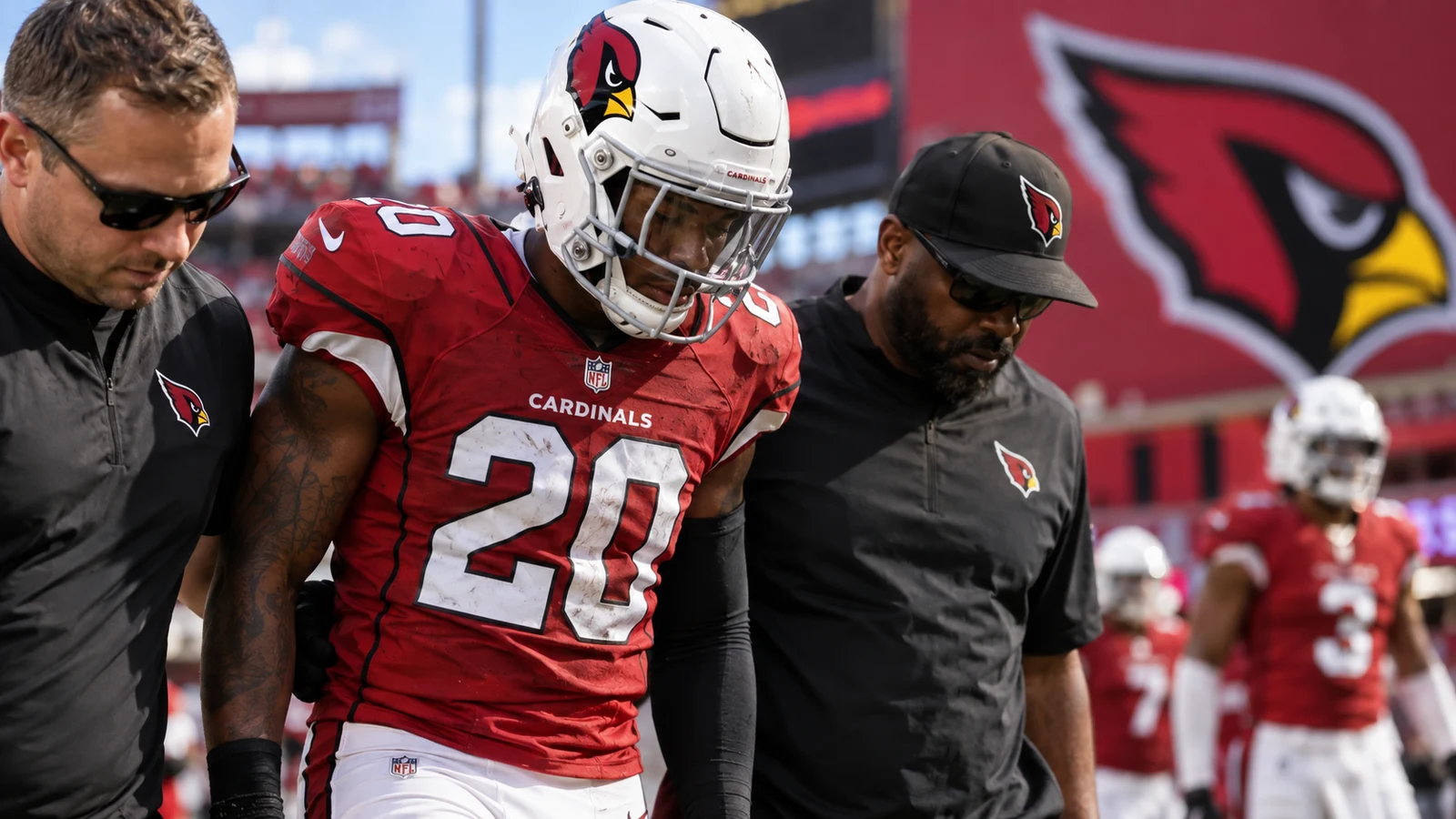 Arizona Cardinals safety Kitan Crawford leaves the field with team staff after an ankle injury.