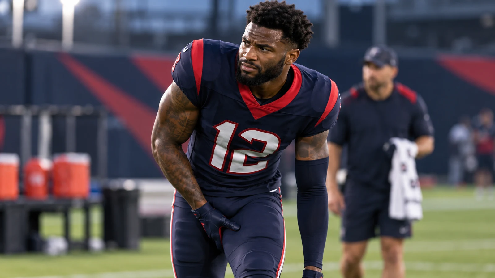Houston Texans wide receiver Nico Collins stretches on the sideline while managing a hamstring issue before Week 2 against Cincinnati.